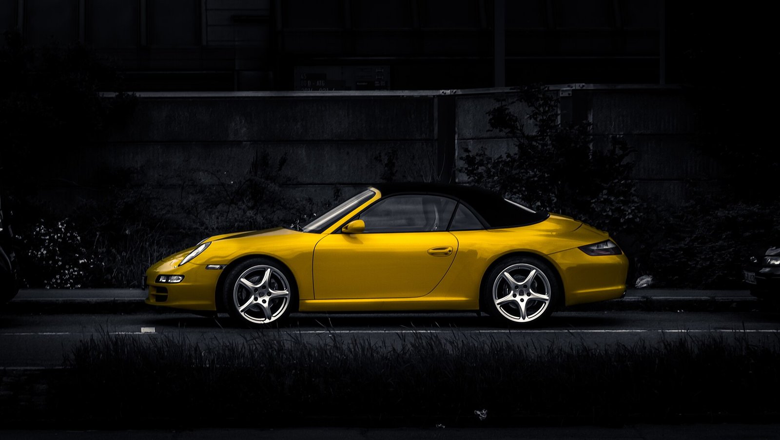 Yellow Porsche 911 with polished paint against a dark background