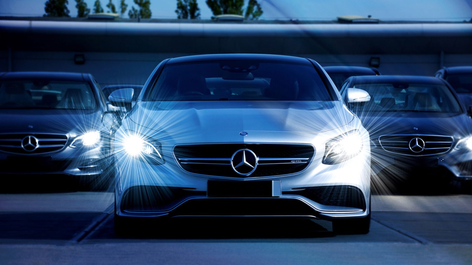 Bright headlights on a silver Mercedes-Benz