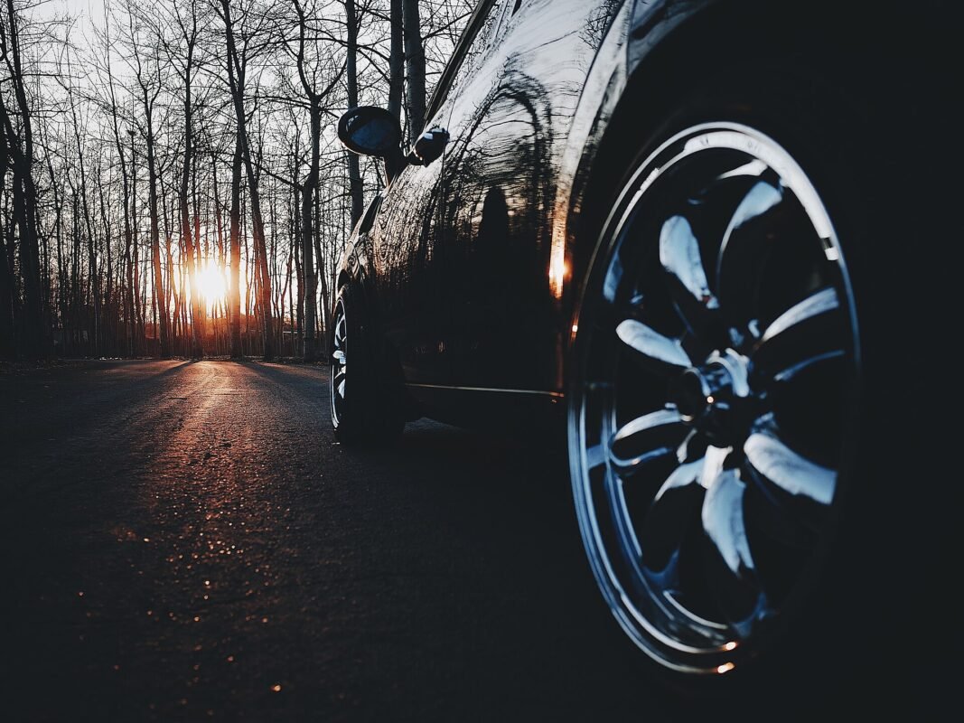 Black car with corrected paint and polished wheel at sunset